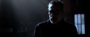 Movie still from “The Unholy” (2021), directed by Evan Spiliotopoulos – An older man wearing glasses in a dark room; Close Up shot, Over the shoulder angle