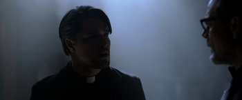 Movie still from “The Unholy” (2021), directed by Evan Spiliotopoulos – A man in a priest's outfit looking into the distance; Close Up shot, Low angle