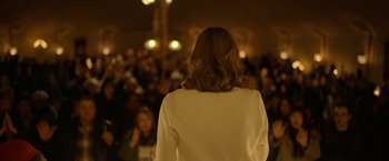 Movie still from “The Unholy” (2021), directed by Evan Spiliotopoulos – A woman standing in front of a crowd of people; Medium shot, Over the shoulder angle