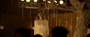 Movie still from “The Unholy” (2021), directed by Evan Spiliotopoulos – A woman in a white dress standing in front of a chandelier; Medium shot, Low angle