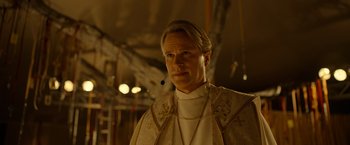 Movie still from “The Unholy” (2021), directed by Evan Spiliotopoulos – A man in a priest's outfit is looking at the camera; Close Up shot, Low angle