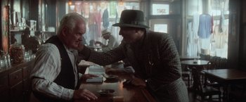 Movie still from “The Untouchables” (1987), directed by Brian De Palma – Two men sitting at a table in front of each other; Medium shot, Over the shoulder angle