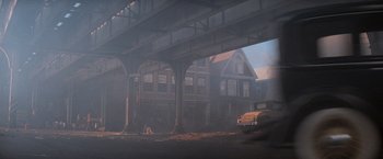 Movie still from “The Untouchables” (1987), directed by Brian De Palma – A car driving under an overpass on a foggy day; Extreme Wide shot, High angle