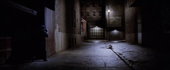 Movie still from “The Untouchables” (1987), directed by Brian De Palma – An empty alley way with a lamp post lit up at night; Extreme Wide shot, High angle