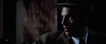 Movie still from “The Untouchables” (1987), directed by Brian De Palma – A person wearing a suit and a hat; Close Up shot, Over the shoulder angle