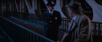 Movie still from “The Untouchables” (1987), directed by Brian De Palma – A police officer talking to a man in a hat; Medium shot, Over the shoulder angle