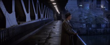 Movie still from “The Untouchables” (1987), directed by Brian De Palma – A man wearing a hat and a trench coat standing in a tunnel; Wide shot, High angle