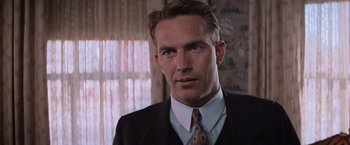Movie still from “The Untouchables” (1987), directed by Brian De Palma – A person wearing a suit and tie; Close Up shot, Over the shoulder angle