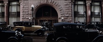 Movie still from “The Untouchables” (1987), directed by Brian De Palma – A group of antique cars parked in front of a building; Extreme Wide shot, High angle