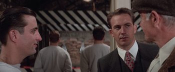 Movie still from “The Untouchables” (1987), directed by Brian De Palma – A man in a suit standing in front of a group of men; Close Up shot, Low angle
