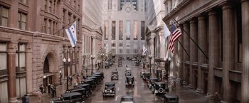 Movie still from “The Untouchables” (1987), directed by Brian De Palma – An image of a street with cars driving down the street; Extreme Wide shot, High angle