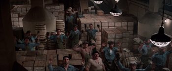 Movie still from “The Untouchables” (1987), directed by Brian De Palma – A group of men standing in front of boxes in a warehouse; Wide shot, High angle