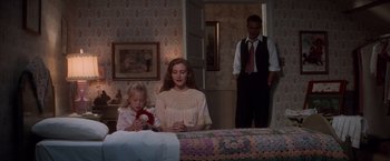 Movie still from “The Untouchables” (1987), directed by Brian De Palma – A woman and a little girl sitting on a bed with a man standing next to them; Wide shot, High angle