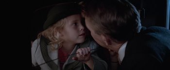 Movie still from “The Untouchables” (1987), directed by Brian De Palma – A little girl and a man are touching noses together; Close Up shot, Over the shoulder angle