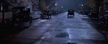 Movie still from “The Untouchables” (1987), directed by Brian De Palma – A row of antique cars parked on the side of the street; Extreme Wide shot, High angle