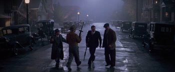 Movie still from “The Untouchables” (1987), directed by Brian De Palma – A group of men walking down a street in the rain; Wide shot, High angle