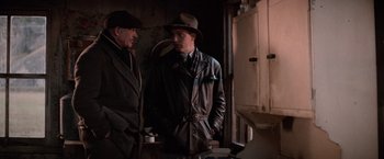 Movie still from “The Untouchables” (1987), directed by Brian De Palma – A man in a hat standing next to another man in a hat; Medium shot, Over the shoulder angle
