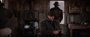 Movie still from “The Untouchables” (1987), directed by Brian De Palma – An older man wearing a hat and a coat; Medium shot, Over the shoulder angle