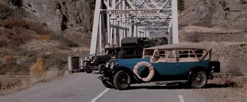 Movie still from “The Untouchables” (1987), directed by Brian De Palma – A group of old cars driving across a bridge; Wide shot, Low angle