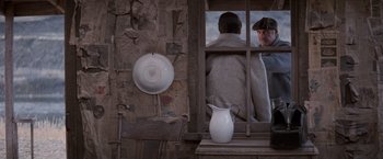 Movie still from “The Untouchables” (1987), directed by Brian De Palma – A man looking out of a window with a white pitcher; Medium shot, High angle