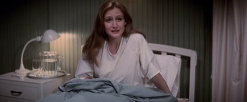 Movie still from “The Untouchables” (1987), directed by Brian De Palma – A woman sitting on a bed in a room; Medium shot, High angle