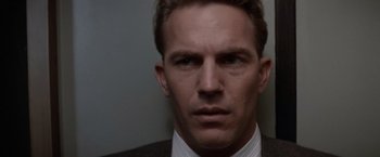 Movie still from “The Untouchables” (1987), directed by Brian De Palma – A person wearing a suit and tie; Close Up shot, Over the shoulder angle