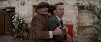 Movie still from “The Untouchables” (1987), directed by Brian De Palma – Two men in suits and hats are hugging each other; Medium shot, Low angle