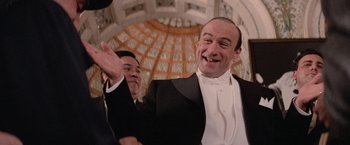 Movie still from “The Untouchables” (1987), directed by Brian De Palma – A man in a tuxedo waving at the camera; Close Up shot, Low angle