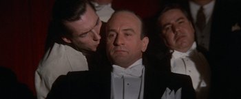 Movie still from “The Untouchables” (1987), directed by Brian De Palma – A man in a tuxedo with two other men in the background; Close Up shot, Over the shoulder angle