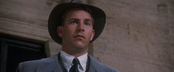 Movie still from “The Untouchables” (1987), directed by Brian De Palma – A person wearing a suit and a hat; Close Up shot, Low angle
