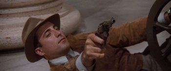 Movie still from “The Untouchables” (1987), directed by Brian De Palma – A man holding a gun while laying on the ground; Close Up shot, Low angle