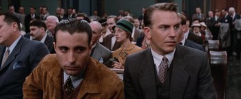 Movie still from “The Untouchables” (1987), directed by Brian De Palma – A group of people sitting in front of a crowd; Close Up shot, Low angle