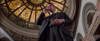 Movie still from “The Untouchables” (1987), directed by Brian De Palma – A man smoking a cigarette in front of a stained glass window; Medium shot, Low angle