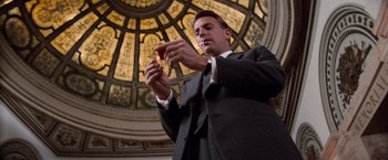 Movie still from “The Untouchables” (1987), directed by Brian De Palma – A man in a suit and tie holding a cell phone; Medium shot, Low angle