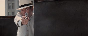 Movie still from “The Untouchables” (1987), directed by Brian De Palma – A man in a hat and a white hat is holding a gun; Close Up shot, Over the shoulder angle