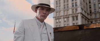 Movie still from “The Untouchables” (1987), directed by Brian De Palma – A man in a white suit and hat standing in front of a building; Close Up shot, Low angle