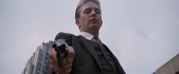 Movie still from “The Untouchables” (1987), directed by Brian De Palma – A man in a suit and tie holding a gun in his hand; Close Up shot, Low angle