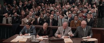 Movie still from “The Untouchables” (1987), directed by Brian De Palma – A group of men sitting in front of each other at a table; Wide shot, High angle