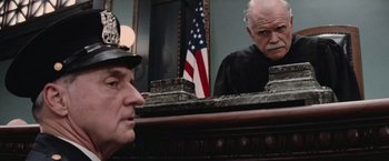 Movie still from “The Untouchables” (1987), directed by Brian De Palma – An older man in a judge's robe looking at himself in the mirror; Close Up shot, Low angle