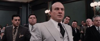 Movie still from “The Untouchables” (1987), directed by Brian De Palma – A man in a suit and tie standing in front of other men; Medium shot, Over the shoulder angle