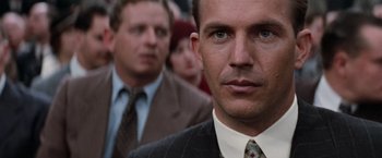 Movie still from “The Untouchables” (1987), directed by Brian De Palma – A person wearing a suit and tie; Close Up shot, Over the shoulder angle