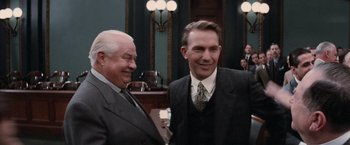 Movie still from “The Untouchables” (1987), directed by Brian De Palma – Two men standing next to each other in a courtroom; Medium shot, Over the shoulder angle