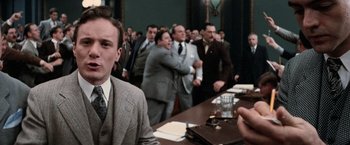 Movie still from “The Untouchables” (1987), directed by Brian De Palma – A group of men in suits and ties standing around a table; Medium shot, Over the shoulder angle