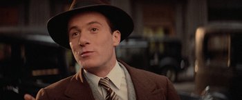 Movie still from “The Untouchables” (1987), directed by Brian De Palma – A person wearing a suit and a hat; Close Up shot, Over the shoulder angle