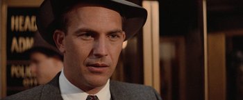 Movie still from “The Untouchables” (1987), directed by Brian De Palma – A person wearing a suit and a hat; Close Up shot, Over the shoulder angle