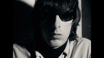 Movie still from “The Velvet Underground” (2021), directed by Todd Haynes – A person wearing sunglasses; Close Up shot, Low angle