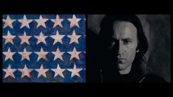 Movie still from “The Velvet Underground” (2021), directed by Todd Haynes – A painting of an american flag and an image of a man with long black hair; Close Up shot, Overhead angle