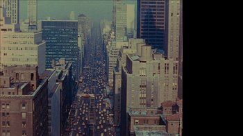 Movie still from “The Velvet Underground” (2021), directed by Todd Haynes – An aerial view of a busy city street with traffic; Extreme Wide shot, High angle
