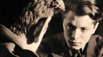 Movie still from “The Velvet Underground” (2021), directed by Todd Haynes – A man looking at himself in the mirror; Close Up shot, Over the shoulder angle