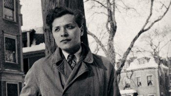 Movie still from “The Velvet Underground” (2021), directed by Todd Haynes – A man in a trench coat standing next to a tree; Close Up shot, Low angle